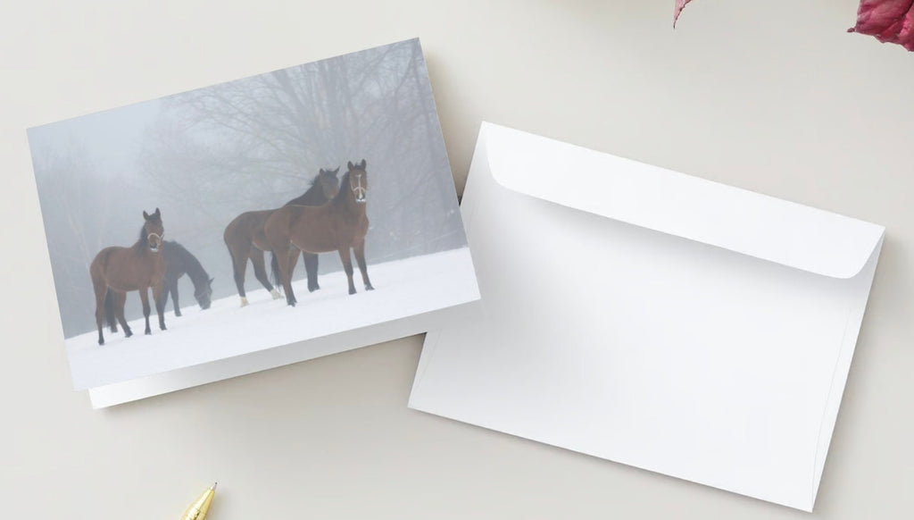Christmas card featuring horses in a snowy background